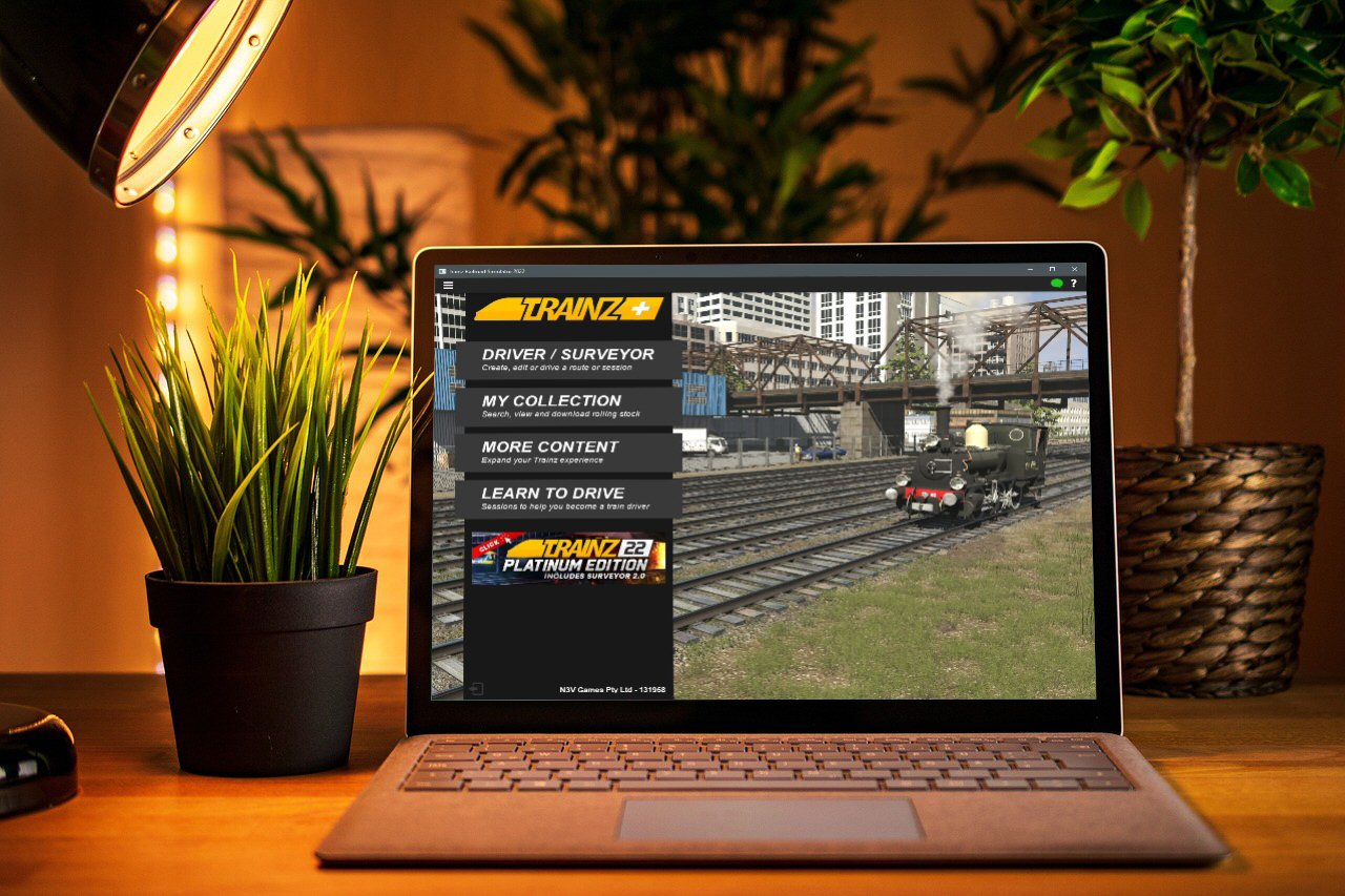 plaatje bureau met laptop met afbeelding hoofdmenuscherm Trainz Plus