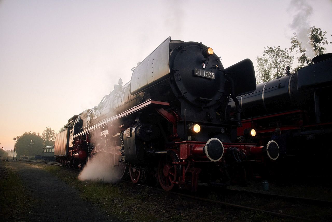 Foto van de stoomlocomitief 01 1075 van de SSN in het ochtendtegenlicht.