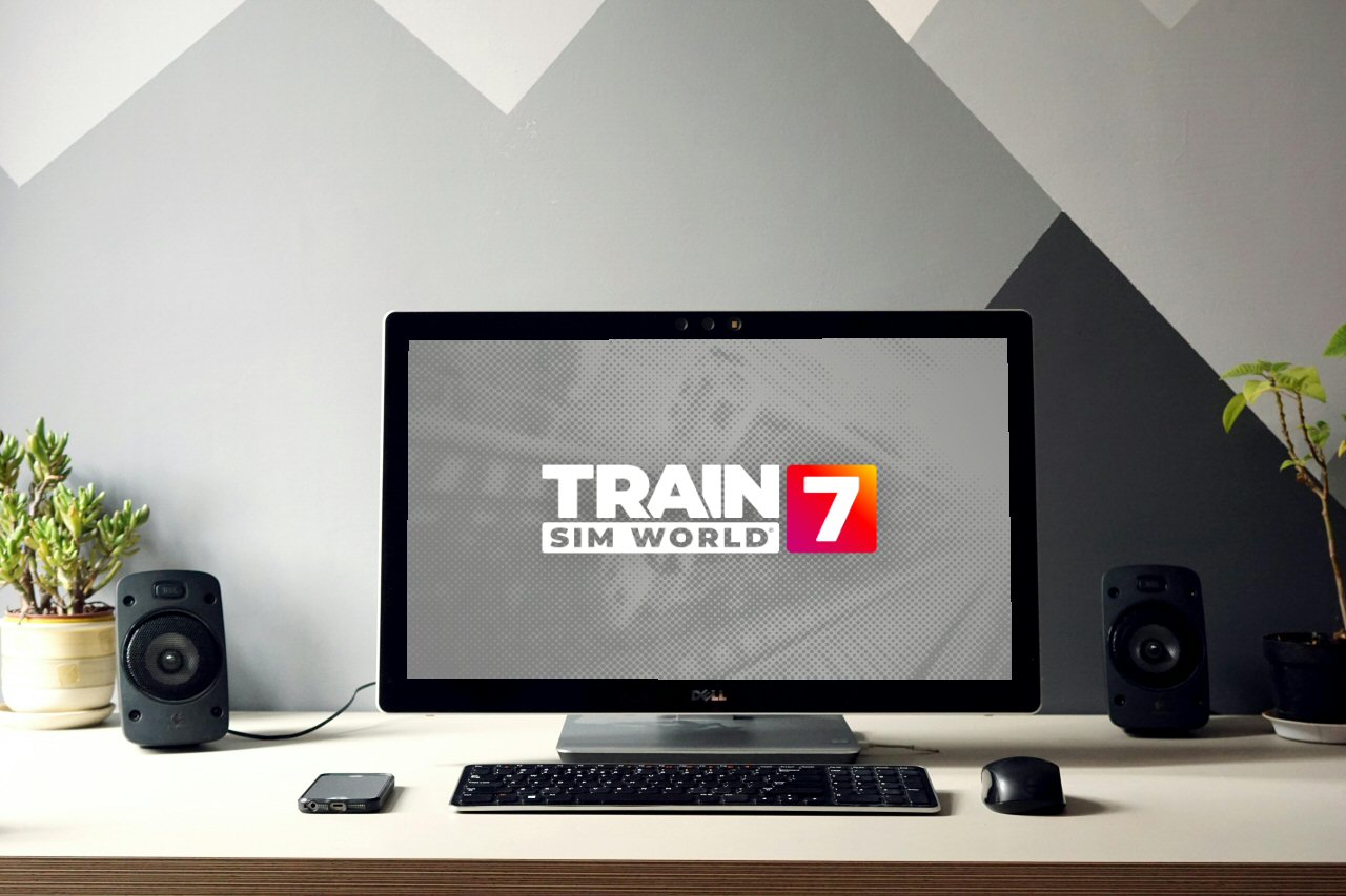 Een plaatje van een bureau met planten en een laptop met een afbeelding Train Sim World 7.
